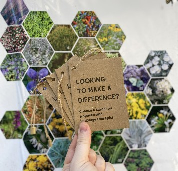 Hand holding a selection of careers booklets in front of a floral background